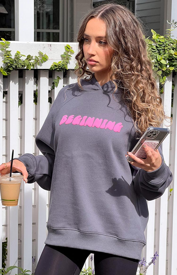 Slate grey oversized hoodie with pink bubble letter 'BEGINNING' graphic on the chest