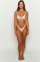 Front view of the high-leg, V-cut swim bottoms with a pink, yellow, and white wavy sun print