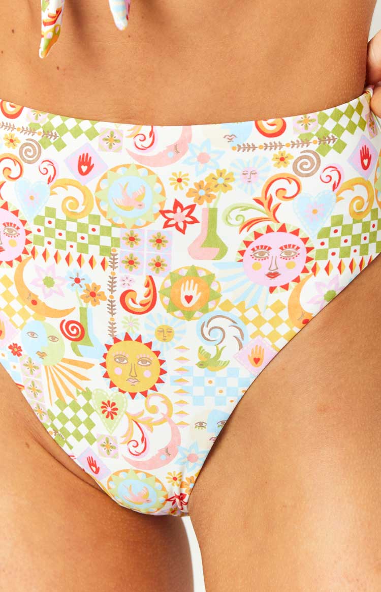 Close-up of the intricate multi-print pattern on the bikini bottoms, featuring suns, moons, flowers, hearts, and checkered details