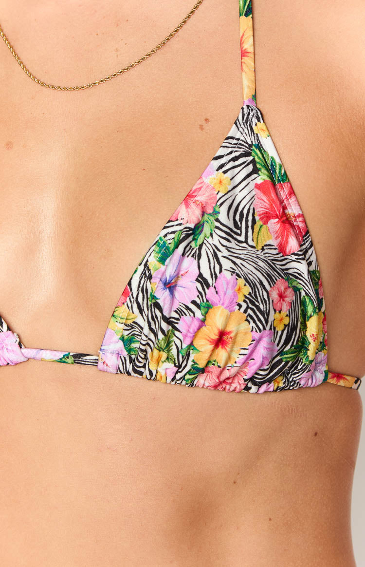Close-up of the white zebra floral triangle bikini top with pink, yellow, and purple flowers and gathered bottom edge