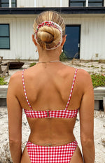 Rear view of a red and white gingham bikini top with thin spaghetti straps and a gold clasp closure