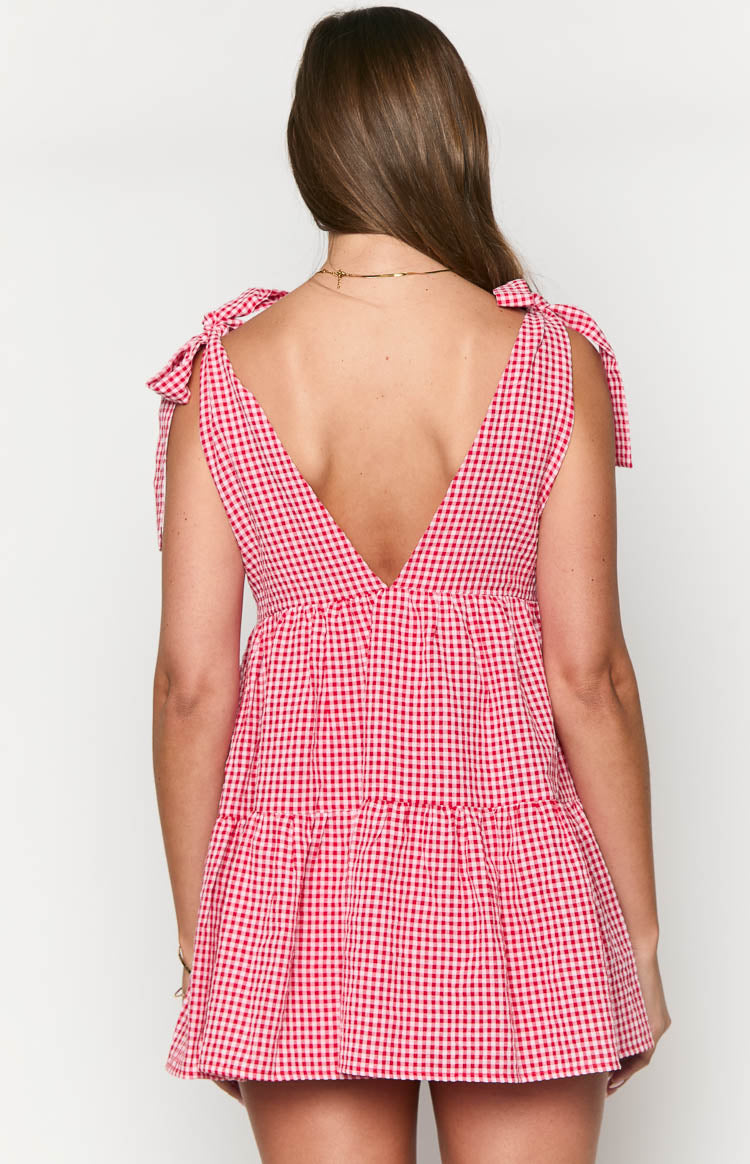 Rear view of a red gingham mini dress with a deep V-back, tie-shoulder straps, and tiered skirt