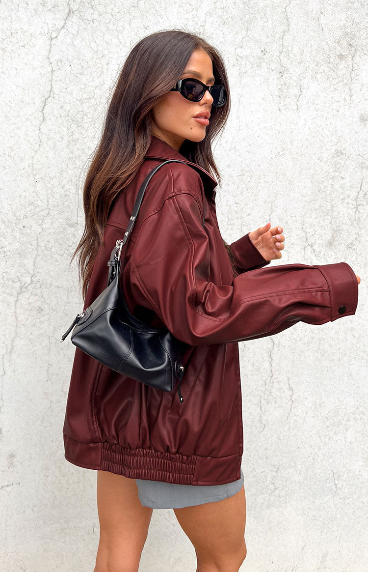 Side view of a red PU bomber jacket showing the oversized fit, long sleeves, and elasticated hem
