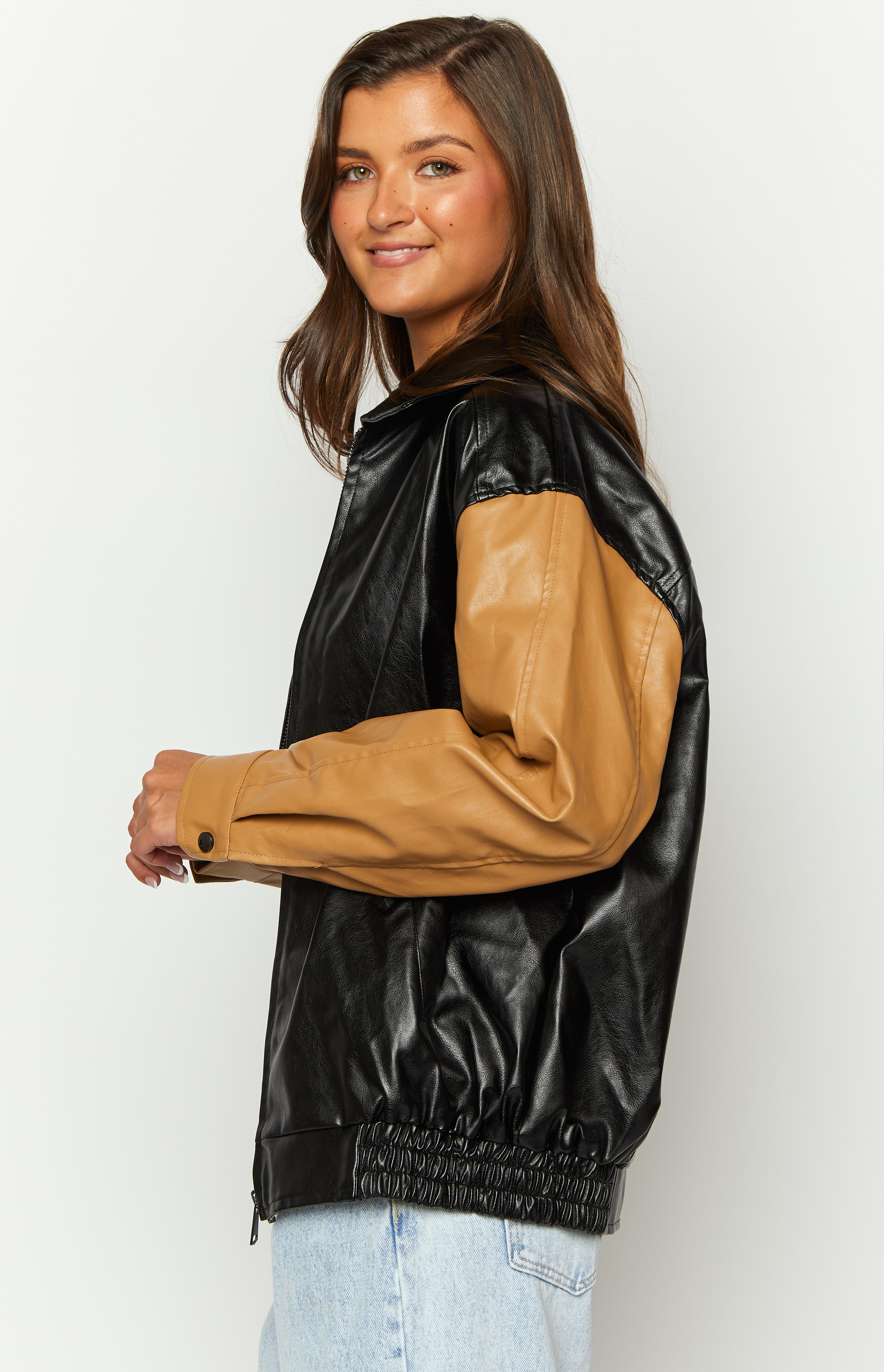 Side view of a black and tan PU bomber jacket with elasticated hem and buttoned cuff