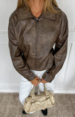 Vintage brown PU bomber jacket with a collared neckline, full zip front, and buttoned cuffs
