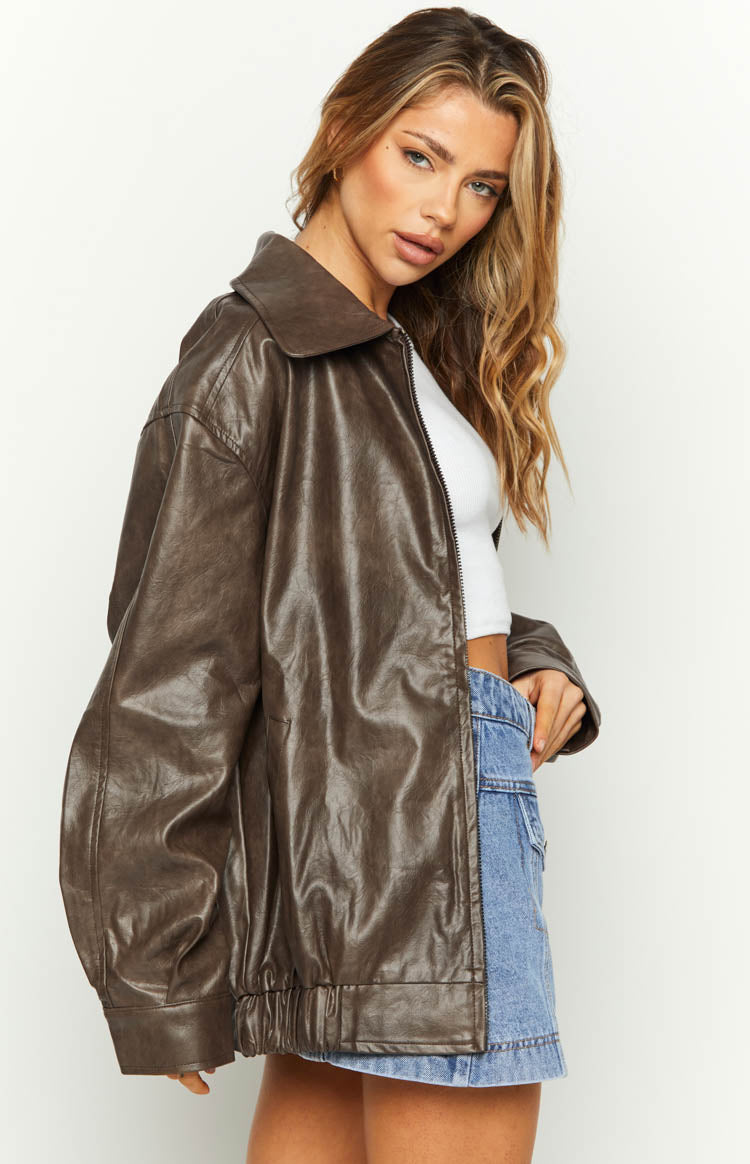 Side view of a brown PU bomber jacket with an oversized fit, dropped shoulders, and elasticated hem