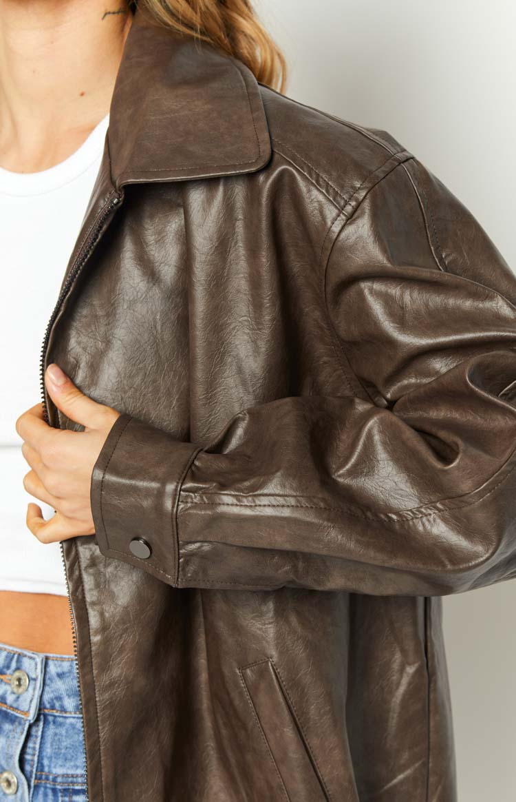 Close-up of the textured brown PU bomber jacket showing the classic collar, front zipper, and buttoned cuff