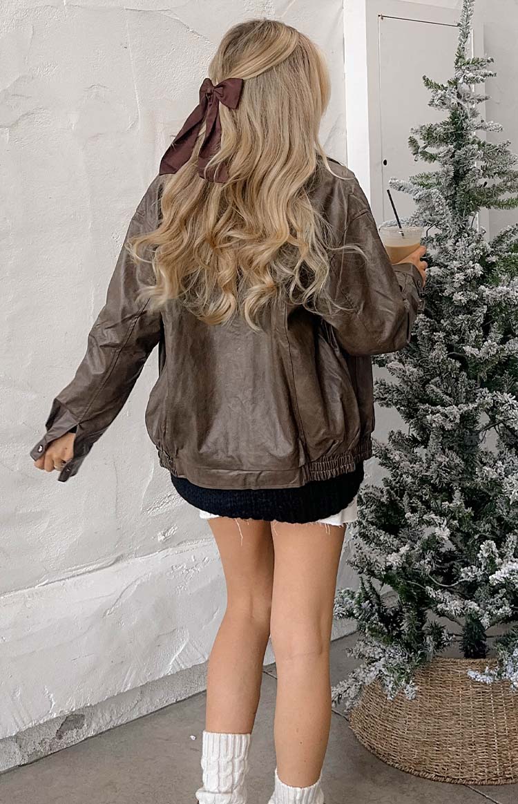 Rear view of a vintage brown PU bomber jacket with a ribbed hem and relaxed fit