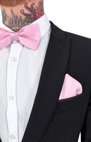 Pink satin bow tie and pocket square set worn with a white textured shirt and black suit