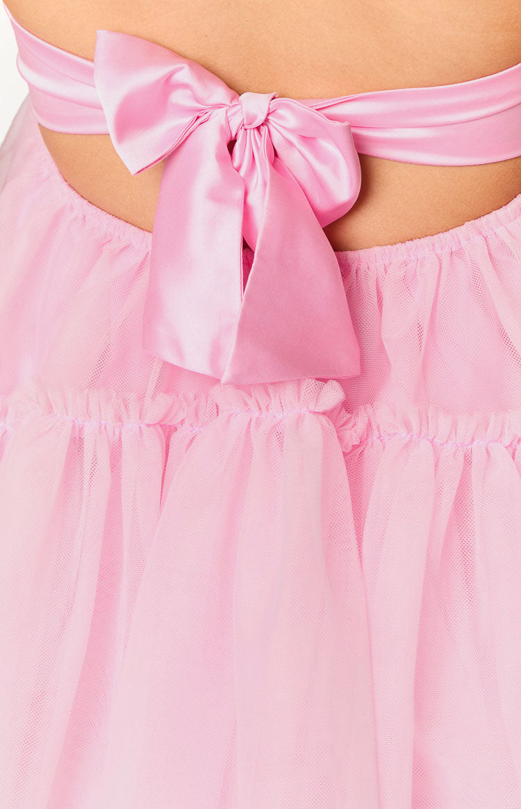 Close-up of a large pink satin bow tied at the back of the mini dress, above gathered pink tulle