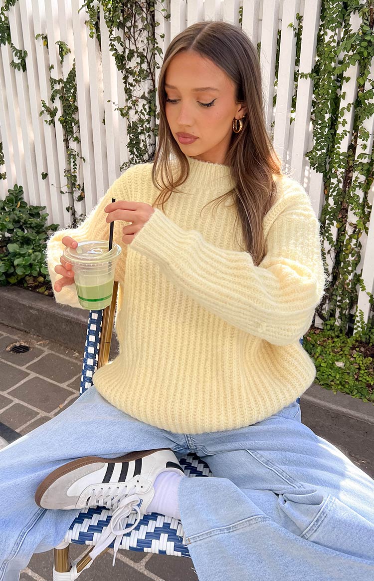 Yellow oversized sweater with a prominent ribbed knit texture and mock neck