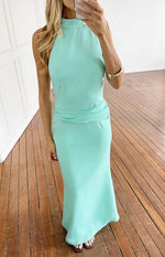 Front view of an aqua halter neck maxi dress with a ruched waist and flowy skirt