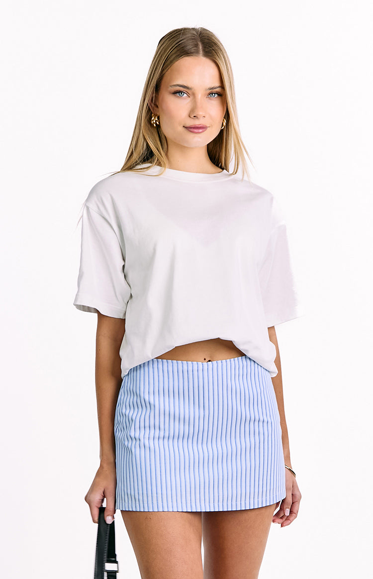 Front view of a light blue mini skort with thin vertical white stripes and a straight cut