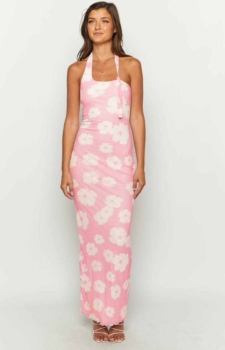 Front view of a pink floral maxi halter dress with a square neckline and tie detail