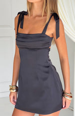 Black satin mini dress with a square neckline, tie-up shoulder straps, ruched bust, and side cutout