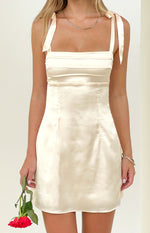 Cream satin mini dress with square neckline, tie shoulders, and horizontal pleated bodice