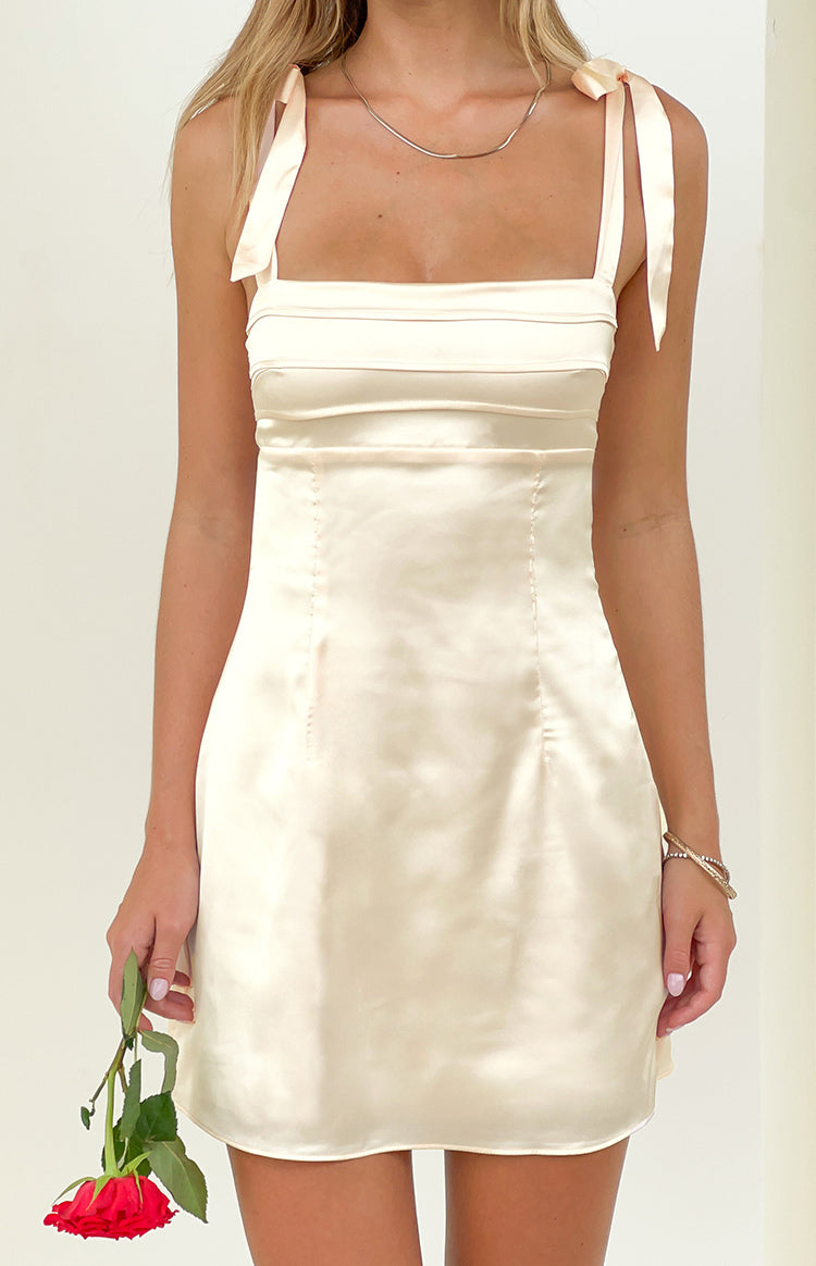 Cream satin mini dress with square neckline, tie shoulders, and horizontal pleated bodice