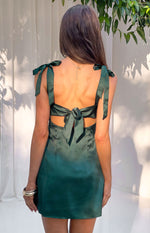 Rear view of a green satin mini dress with shoulder ties, a large back bow, and cutouts at the waist