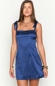 Navy satin mini dress with square neckline, tie shoulders, and horizontal panel detailing on the bodice
