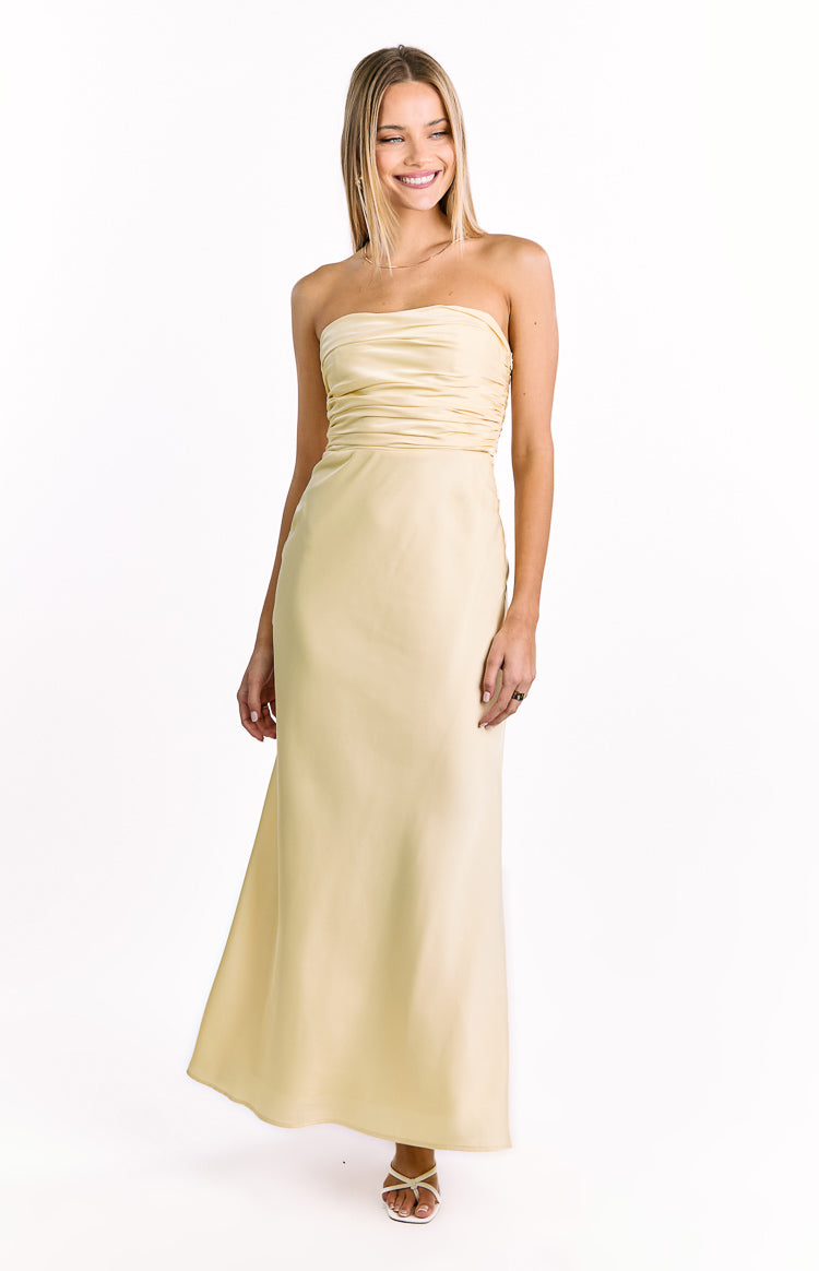 Front view of a pale yellow strapless maxi dress with a ruched bodice and a flowing A-line skirt