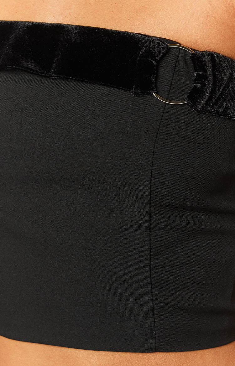 Close-up of the black velvet trim and silver O-ring detail on a black strapless top