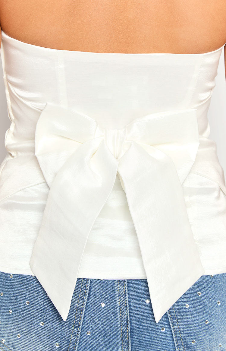 Rear view of the white strapless top showing a large, structured bow detail at the back