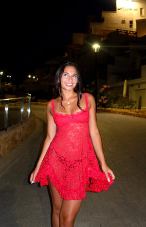 Red lace mini dress with a square neckline, thin straps, small bow detail, and a flowy ruffled hem