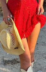 Close-up of the red lace mini dress with a detailed floral pattern and a delicate ruffled hem