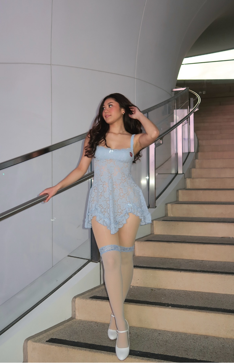 Full length view of a blue lace mini dress with a scoop neckline, thin straps, and a flowy scalloped hem