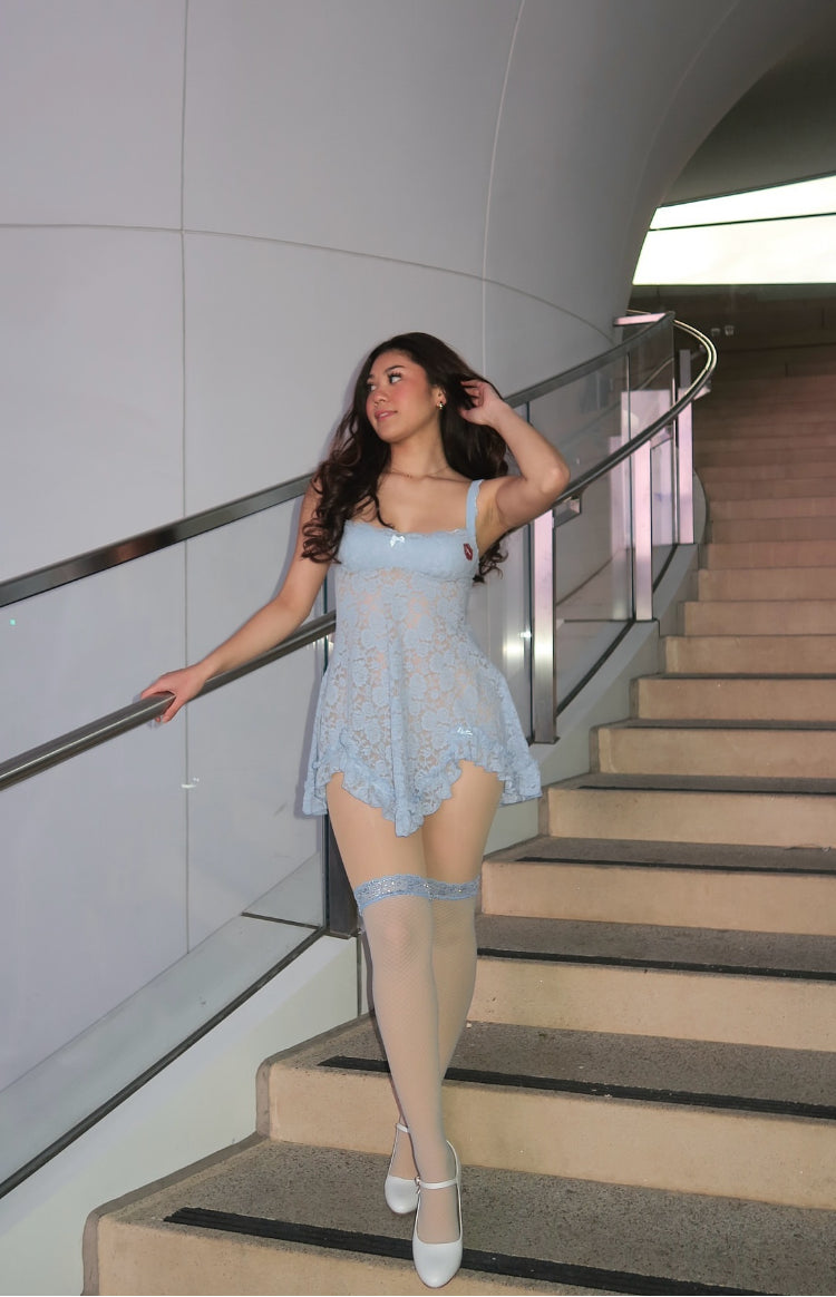 Full length view of a blue lace mini dress with a scoop neckline, thin straps, and a flowy scalloped hem