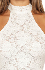 Close-up of the white floral lace fabric, showing the high neck and sleeveless design of the mini dress