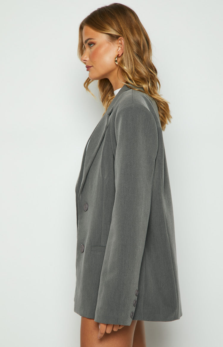 Side view of a grey double-breasted blazer with wide lapels, long sleeves, and buttoned cuffs