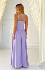 Rear view of a lilac crepe maxi dress with a square back, thin spaghetti straps, and gathered flowing skirt