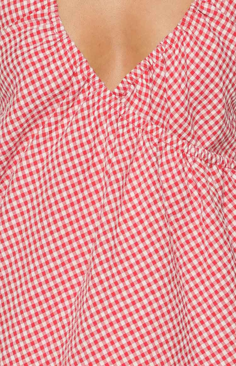 Close-up of the red and white gingham V-neckline with ruched bodice detail on the mini dress