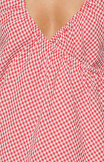 Close-up of the red and white gingham V-neckline with ruched bodice detail on the mini dress
