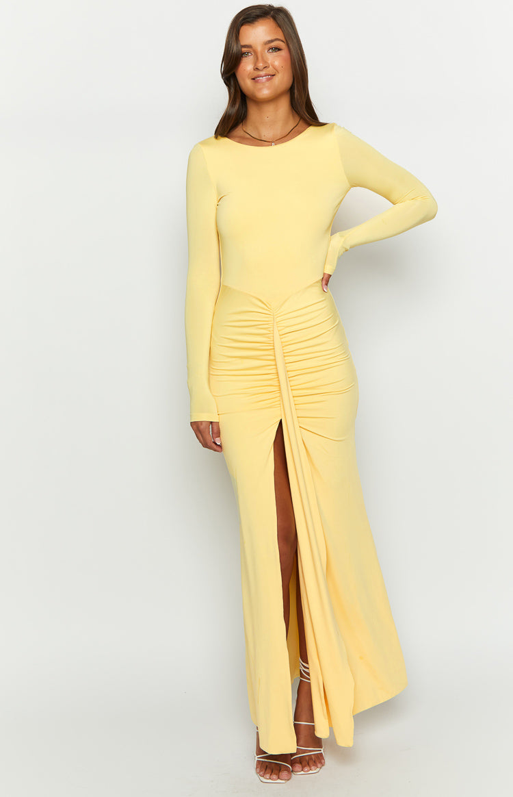 Front view of a yellow long sleeve maxi dress with a ruched front detail and high thigh split