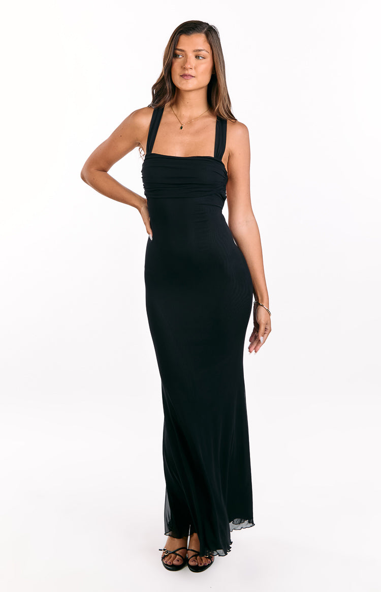 Full front view of a black mesh maxi dress with a ruched square neckline, wide straps, and a ruffled hem