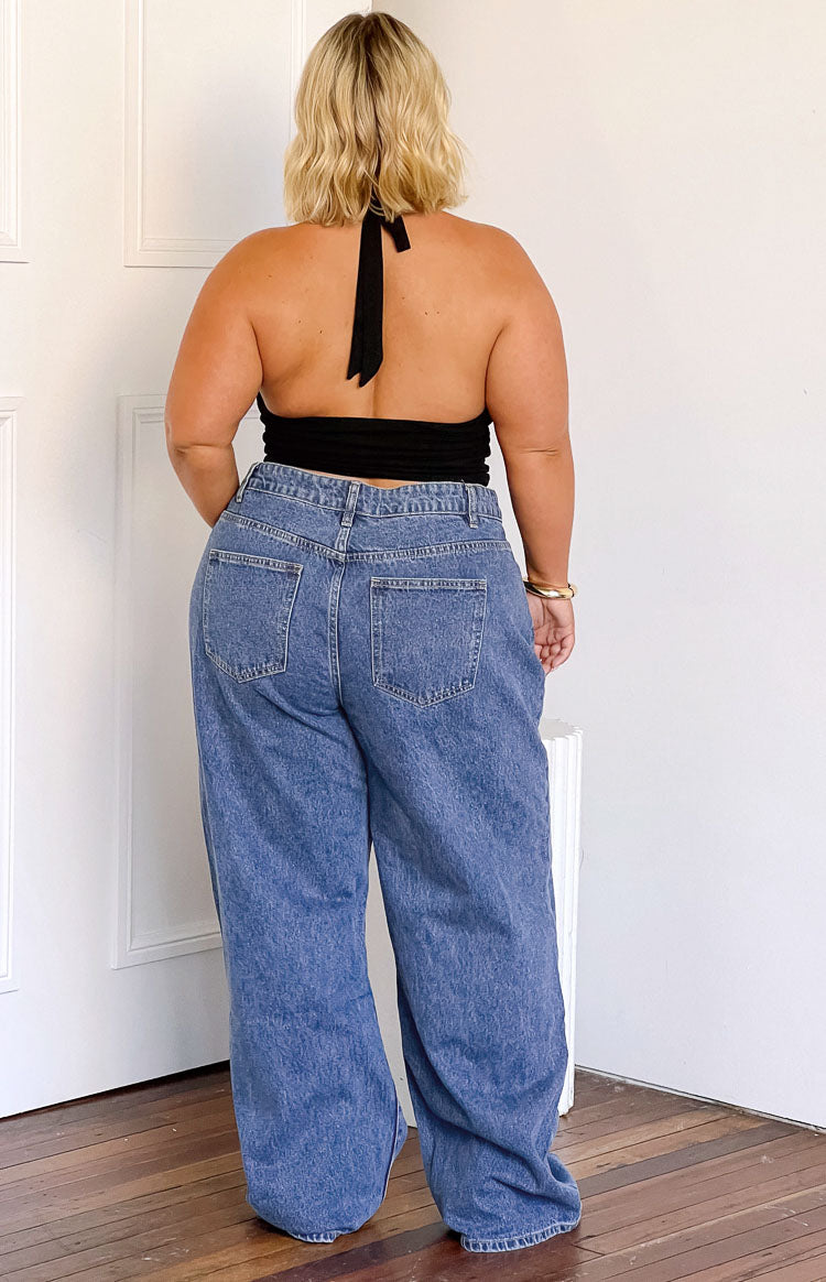 Rear view of a black halter crop top with an open back and tie neck closure