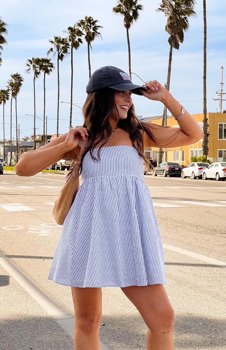 Front view of a blue and white stripe strapless mini dress with a gathered empire waist and flowy A-line skirt