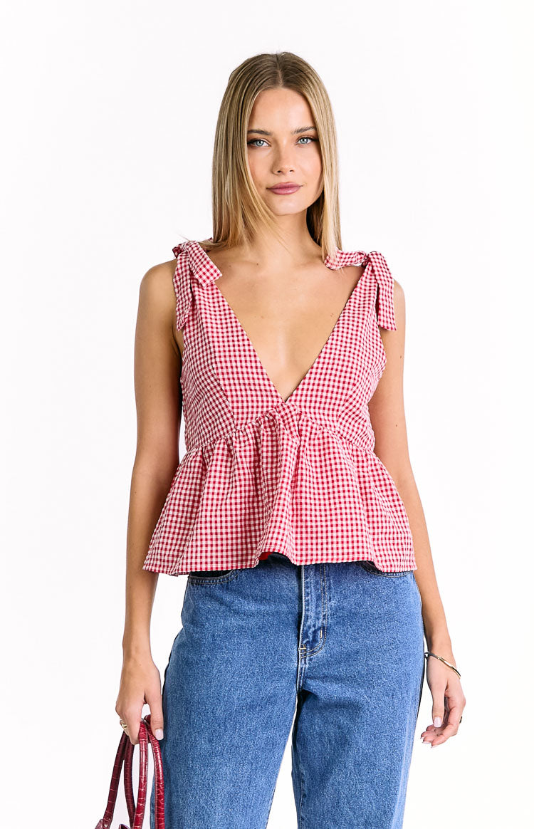 Red gingham top with a deep V-neckline, tie shoulders, and a gathered peplum hem