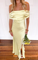 blonde model wearing a yellow satin off shoulder formal gown with ruffle details at the split