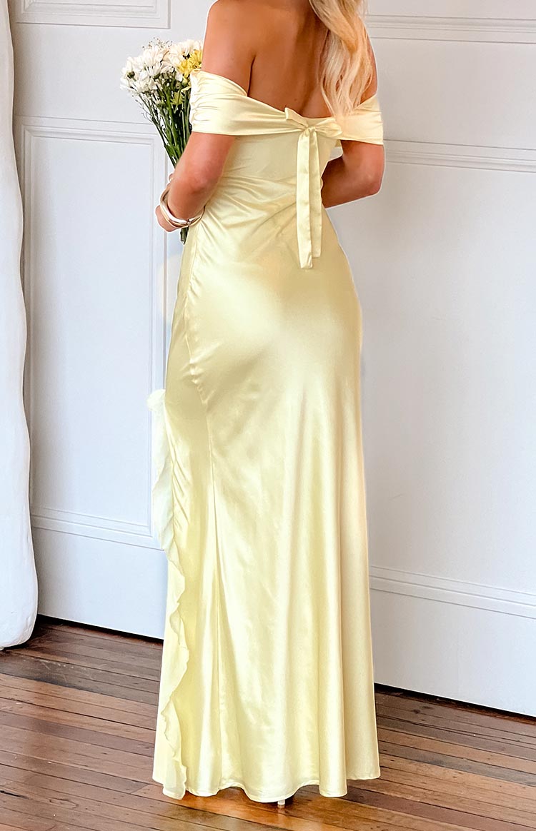 Rear view of a yellow off-shoulder maxi dress with a tie-back detail and side ruffle