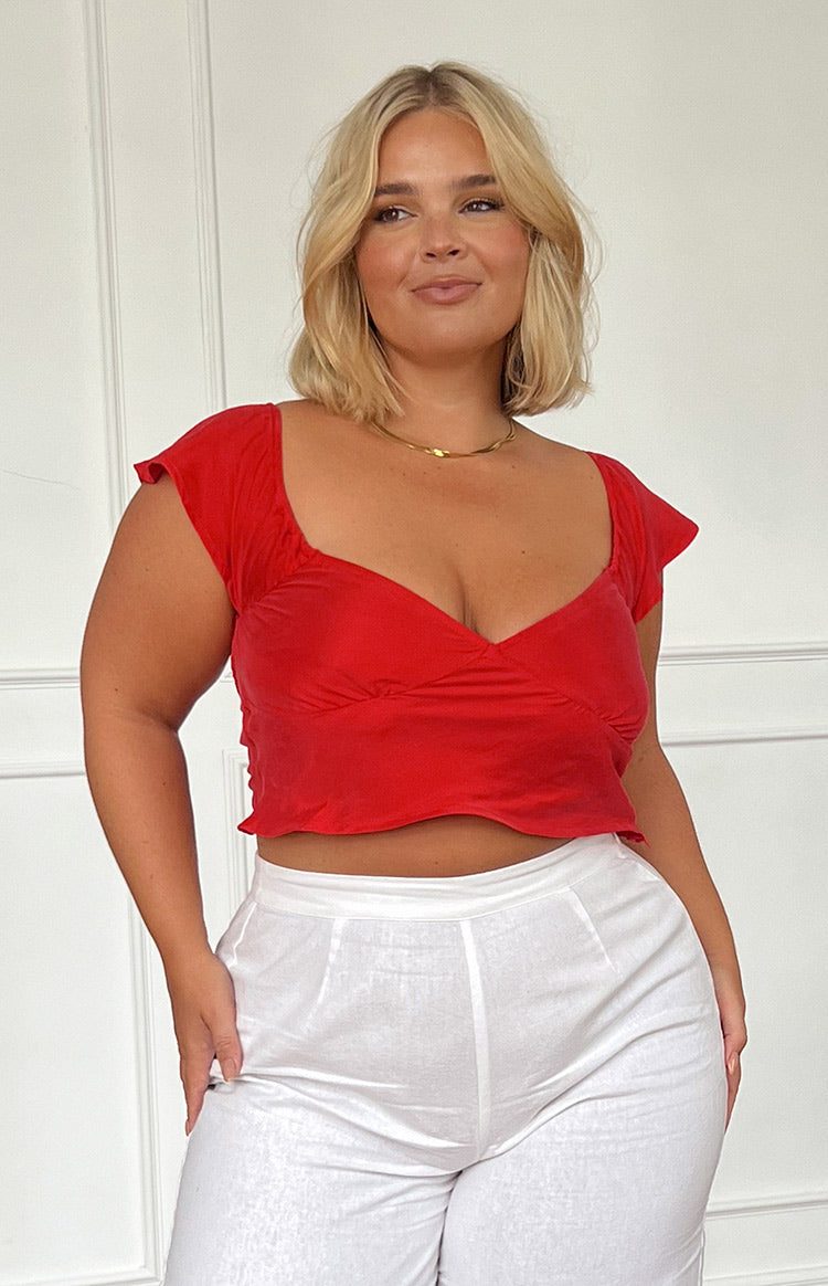 Front view of a red cropped top with a sweetheart neckline, ruched bust, and short flutter sleeves