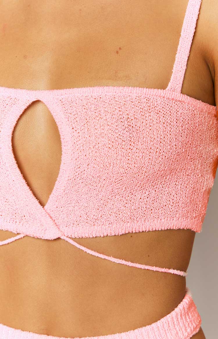 Close-up of the front cutout detail and wrap-around waist ties on a pink knit crop top