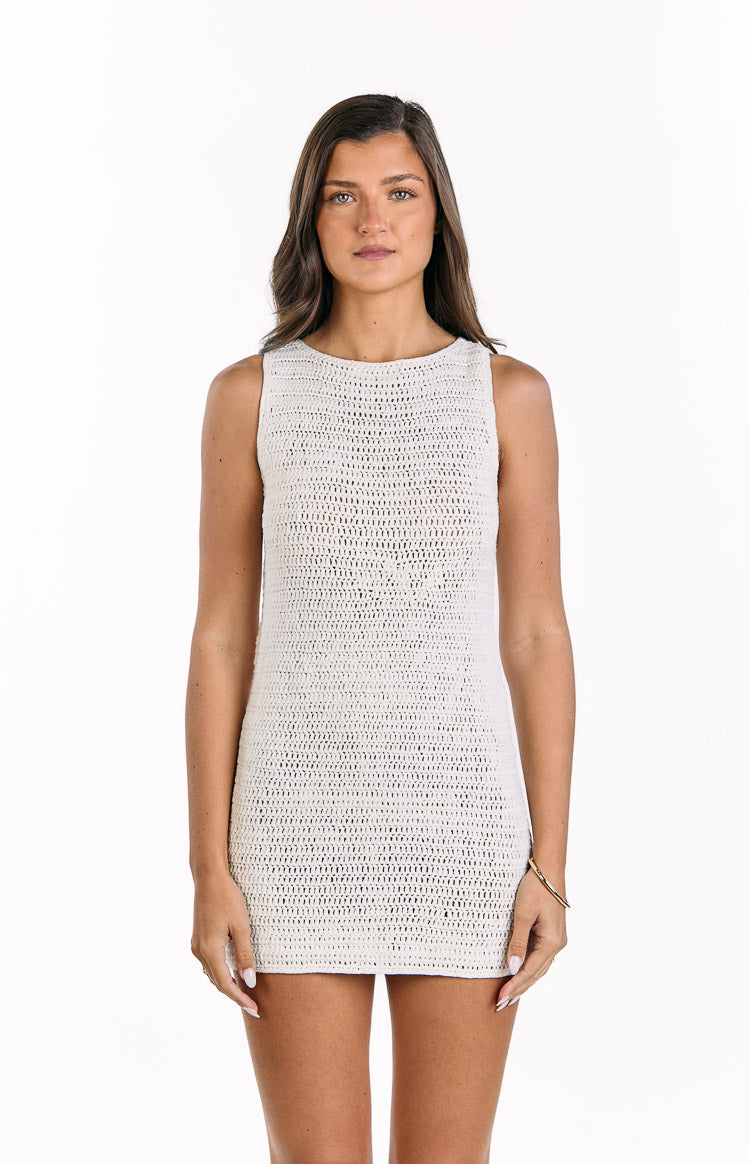 Front view of a cream crochet mini dress with a boat neckline and sleeveless design