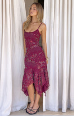 Side view of a plum sequin midi dress with spaghetti straps, square neckline, and a flowy handkerchief hem