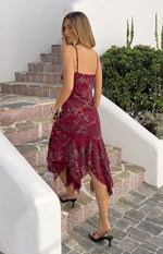 Rear view of a plum sequin midi dress with a square back, thin spaghetti straps, and an asymmetrical handkerchief hem