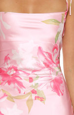 Close-up of the pink satin maxi dress fabric with a vibrant pink and white floral print and thin strap