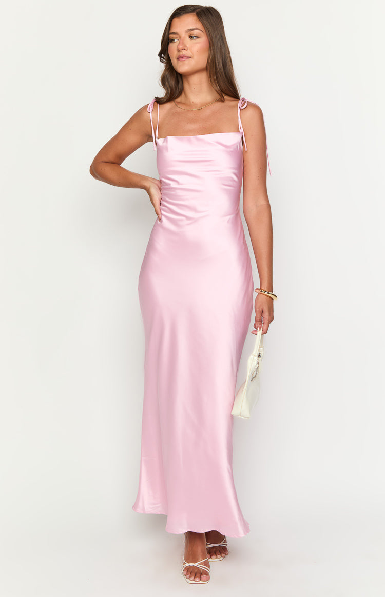 Front view of a pink satin maxi dress with a square neckline, tie-up spaghetti straps, and a ruched side