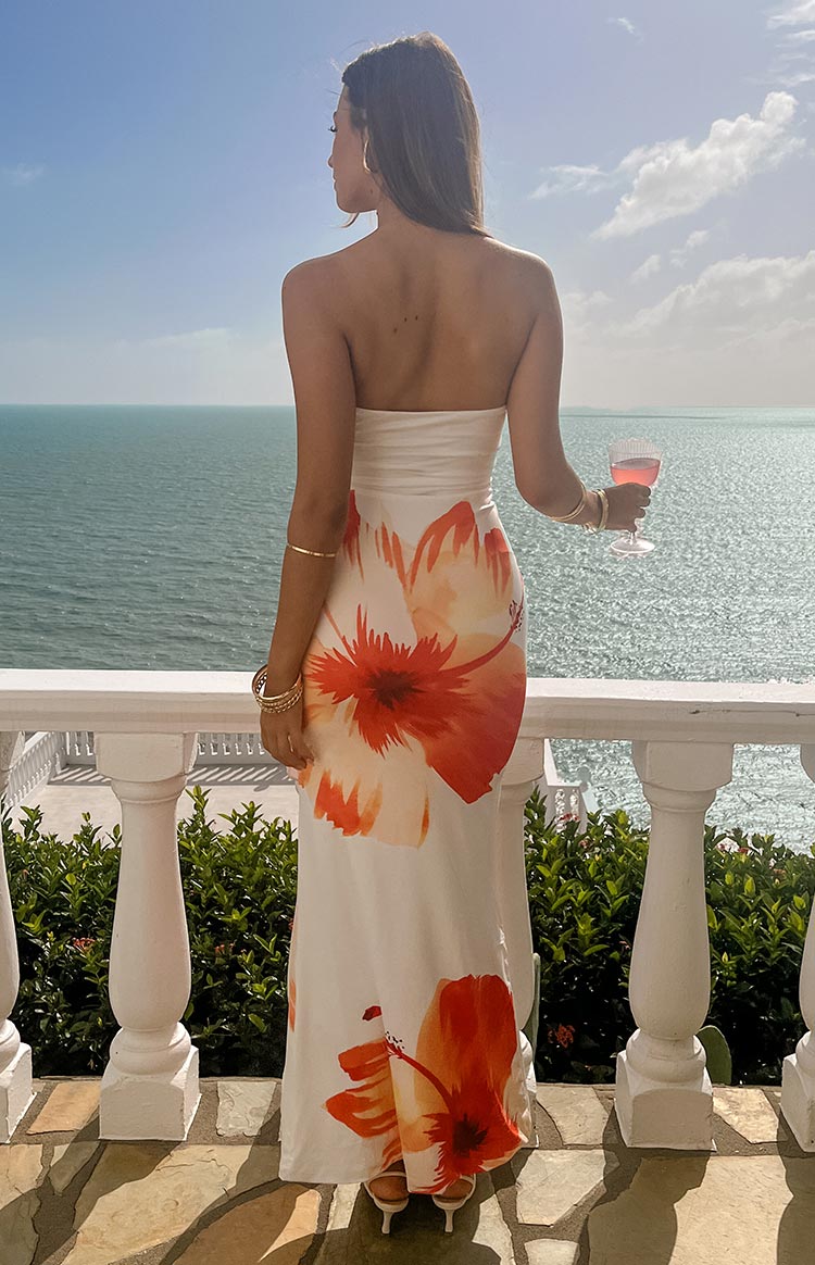 Rear view of a white strapless maxi dress with large orange and red hibiscus floral print on the back